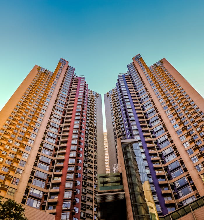 Tall, colorful skyscrapers reaching into the blue sky in Hong Kong, showcasing modern architecture.